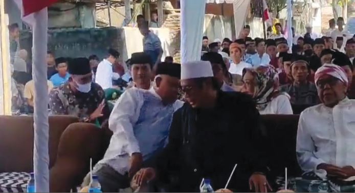 NYAGUB YUK: HM Suhaili FT (kopiah putih) tengah dibisiki HM Sukiman Azmy (kopiah hitam) di acara Halal Bihalal di Dusun Bageq Belang, Desa Sikur Selatan, Lombok Timur, Sabtu (21/5). (TANGKAPAN LAYAR VIDEO)
