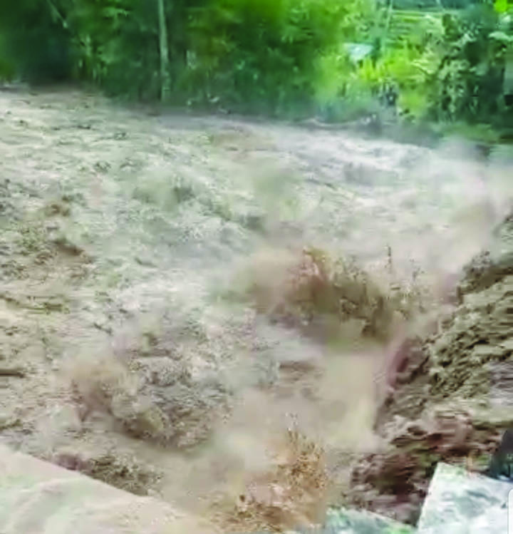 Debit air di Kali Meninting yang sangat deras akibat jebolnya tanggul pengelak proyek Bendungan Meninting, Jumat (17/6) sore. (Foto: tangkapan layar video)