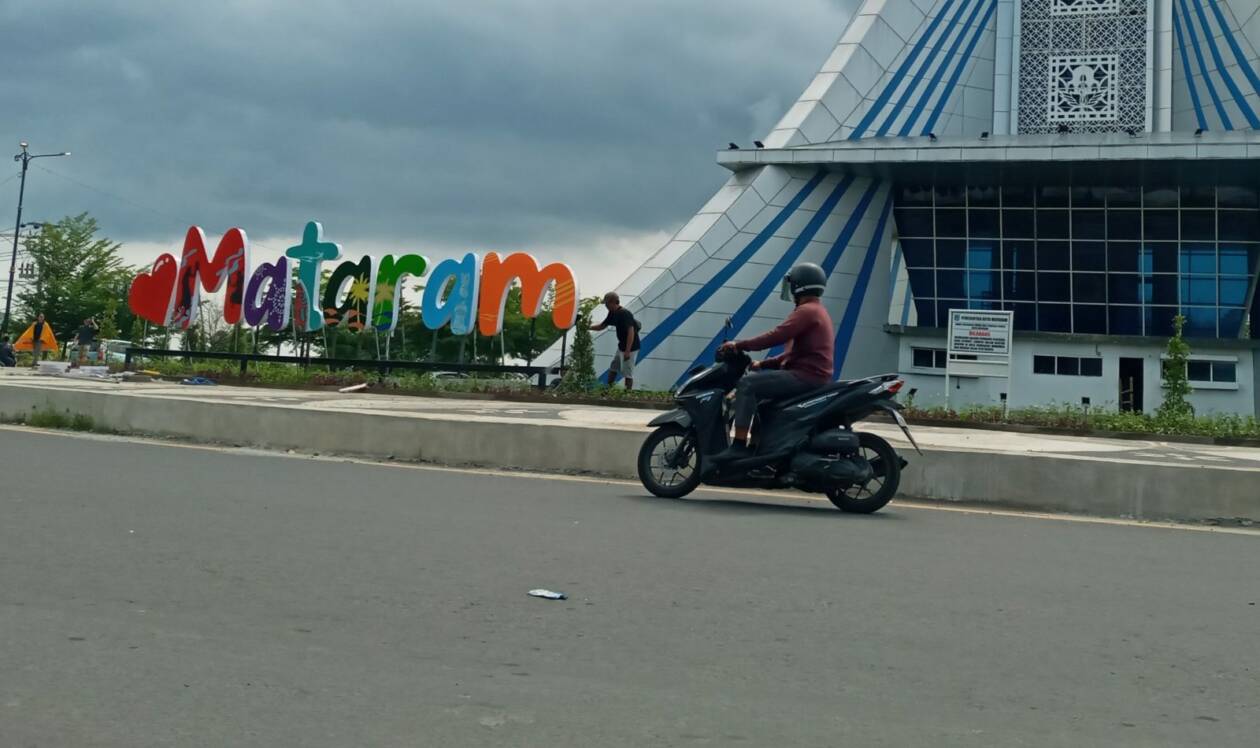 MASIH DIKERJAKAN: Seorang pekerja membuat simbol kota berupa tulisan “Cinta Mataram di area Monumen Mataram Metro, Kota Mataram, beberapa waktu lalu. (ROJAI/LOMBOK POST