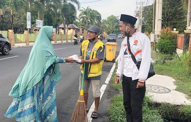 BERBAGI: Para pengurus dan kader PKS Kota Mataram saat membagikan bantuan sembako kepada warga kota yang bekerja sebagai petugas kebersihan. (IST/LOMBOK POST)