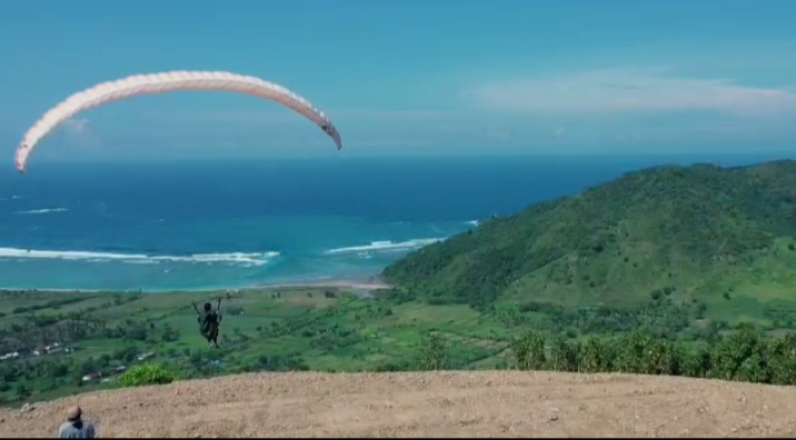 WISATA PARALAYANG: Pilot paralayang lepas landas dari atas perbukitan tak jauh dari kawasan Mandalika, belum lama ini.