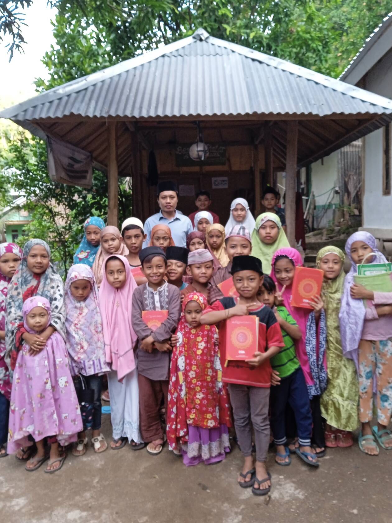 BELAJAR BERSAMA: Ketua Tim Pengabdian Kepada Masyarakat Prodi KPI Ummat bersama anak-anak usai belajar surat pendek, untuk Program Berugak Pintar Anak Sholeh, Dusun Murpayung Daya, Desa Sigar Penjalin, Kecamatan Tanjung, Kabupaten Lombok Utara, pekan lalu