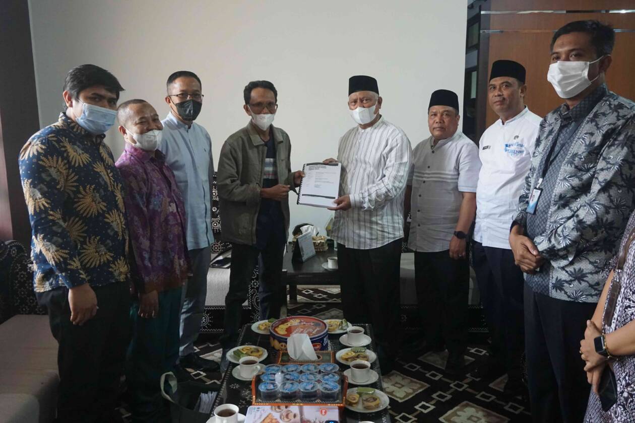 PETA JALAN: Bupati Lotim HM Sukiman Azmy menerima buku panduan perlindungan inklusif bagi komunitas PMI yang disusun ADBMI Lotim di ruangan kerja bupati Lotim, Jumat (22/7). (Fatih/Lombok Post)