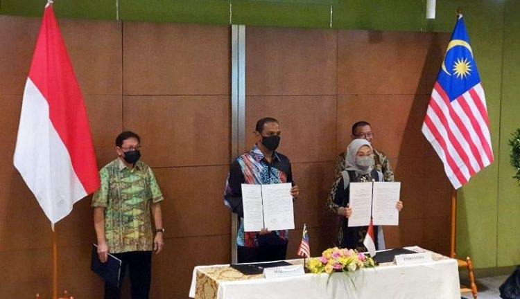 KERJA SAMA: Menteri Ketenagakerjaan (Menaker) RI Ida Fauziyah (kanan) dan Menteri Sumber Daya Manusia Malaysia M. Saravanan Murugan (kedua kiri) menandatangani Joint Statement terkait implementasi penandatanganan nota kesepahaman (MoU) tentang Penempatan