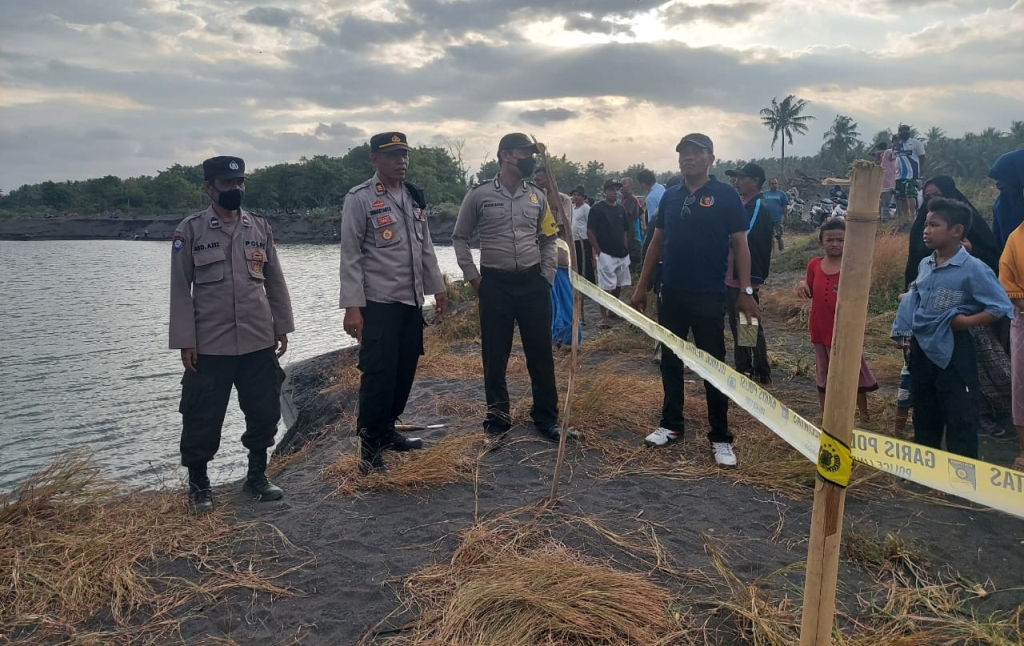 PASANG GARIS POLISI: Kapolsek Pringgabaya AKP Totok Suharyanto bersama anggotanya memasang garis polisi di lokasi penemuan kapal tua yang terdampar di pantai Muara Harapan, Dusun Dedalpak, Desa Pohgading, Kecamatan Pringgabaya, Minggu (17/7). (Polsek Prin