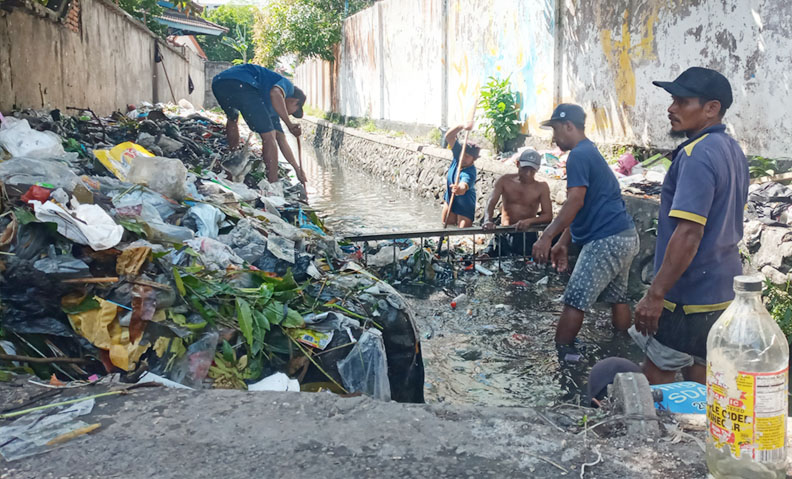 BELUM ADA SOLUSI: Sejumlah petugas membersihkan sampah di kali Jalan Panjitilar, Kecamatan Sekarbela, Kota Mataram. Hingga kini sampah saluran ini belum ada solusi. (Foto: Rojai/Lombok Post)