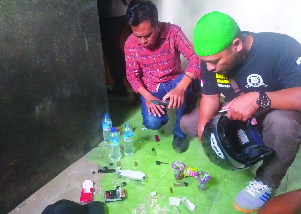 TEMUKAN BUKTI: Warga bersama polisi menemukan peralatan menggunakan sabu yang masih berserakan di lantai kos milik AS di Sesela, Gunungsari, Lobar, Kamis (11/8) malam. (Foto: Harli/Lombok Post)