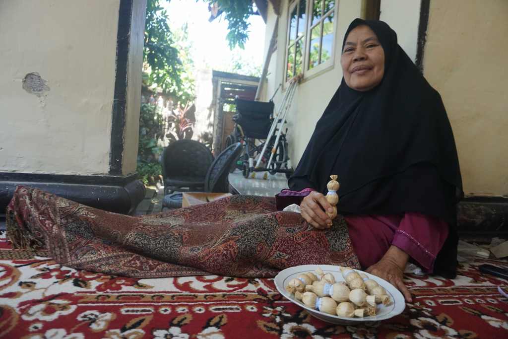 PELOPOR: Hj Rohyati, 66 tahun memperlihatkan kerake ‘bagus rase’, jajanan khas Kelayu yang diproduksi sejak 1986 di rumahnya, Lingkungan Kokok Lauk 2, Kelurahan Kelayu Selatan, Kecamatan Selong, Senin (15/8). (Fatih/Lombok Post)