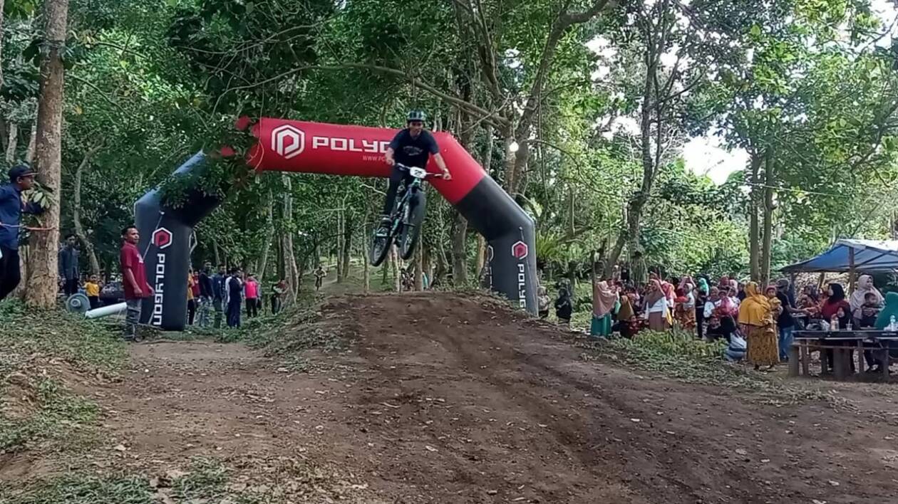 FINISH: Salah seorang peserta balap sepeda King Of Bornong Enduro melewati garis finish di Bornong Bike Park, Desa Aik Prapa, Kecamatan Aikmel, Sabtu (27/8) lalu. (Dedi for Lombok Post)