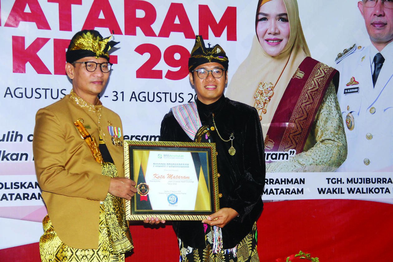 BERIKAN PENGHARGAAN: Kepala BPJS Kesehatan Cabang Mataram Sarman Palipadang memberikan penghargaan kepada Wali Kota Mataram H Mohan Roliskana atas komitmennya mewujukan Universal Health Coverage (UHC) kepesertaan JKN-KIS BPJS Kesehatan. (TONI/LOMBOK POST)