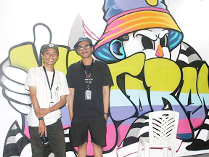 TETAP BERKREASI: Wang Arzaki (kiri) bersama rekannya saat membuat lukisan grafiti di acara Mataram Fair. (Foto: Toni/Lombok Post)