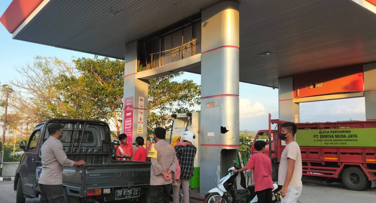 CEGAH KEMUNGKINAN TERBURUK: Sejumlah personel Polres Lotara tengah berjaga di salah satu SPBU di KLU, Minggu (4/9). (Ferial/Lombok Post)
