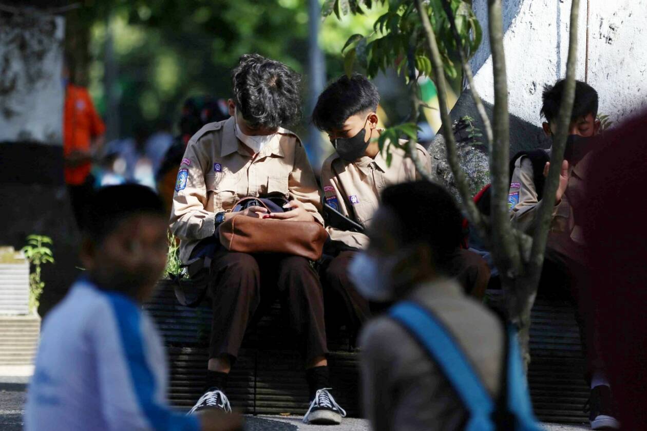 ATURAN DIKAJI ULANG: Dua anak berseragam sekolah, terlihat memeriksa sesuatu melalui gawainya, beberapa waktu lalu.
