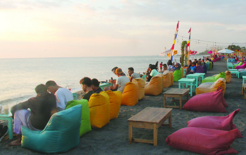 IDOLA BARU: Sejumlah warga menikmati kuliner ditemani pemandangan matahari terbenam di Pantai Sunset Land, Kamis sore (1/9). (Foto: Toni/Lombok Post)