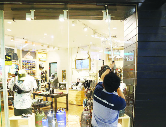 BAKAL DAPAT BANTUAN: Seorang pekerja di Lombok Epicentrum Mall membersihkan kaca belum lama ini. (Foto: Ivan/Lombok Post)