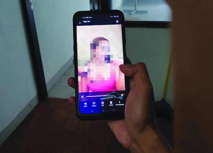 JANGAN DITIRU: Seseorang menonton video asusila yang diduga disebarkan oleh LWH di grup WhatsApp. (Foto: Lombok Post)