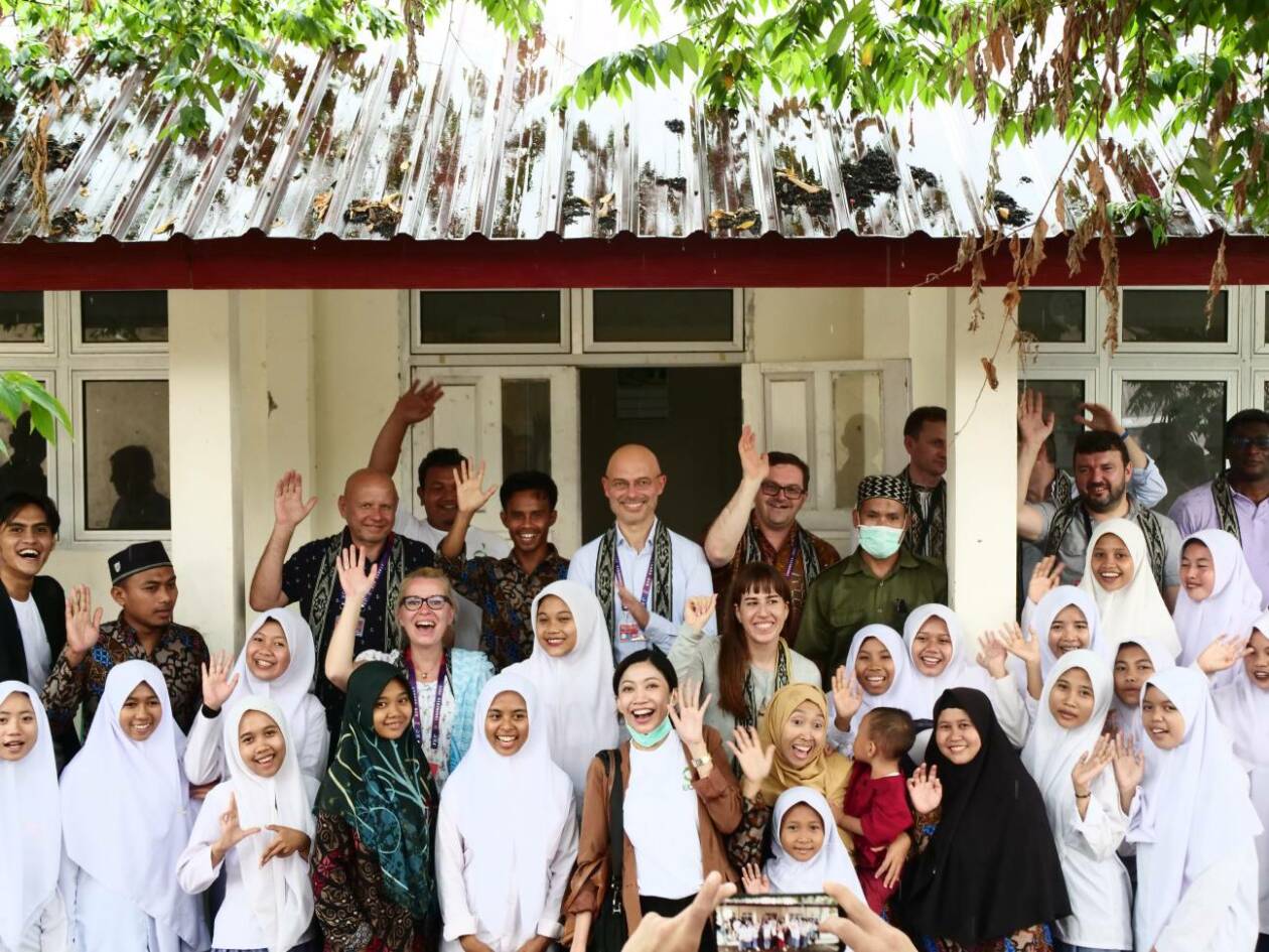 BERFOTO BERSAMA: Delegasi KTT G20 dan pihak Yayasan Youth ECCO Indonesia berfoto bersama dengan guru serta siswa MA Radlul Jannah NWDI Penjor di Desa Genggelang, KLU, Rabu (16/11).