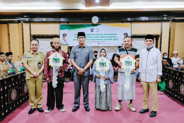 SALURKAN BANTUAN: Wali Kota Mataram H Mohan Rolisakana (tengah) bersama Ketua Baznas Kota Mataram H Jaswad saat menyalurkan dana zakat kepada warga yang berhak menerima, kemarin (22/11).