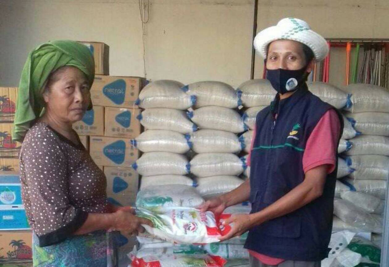 SERAHKAN BPNT: Pendamping BPNT (kanan) menyerahkan bantuan pada salah satu warga KLU yang terdaftar sebagai penerima, beberapa waktu lalu.(DINSOS FOR LOMBOK POST)