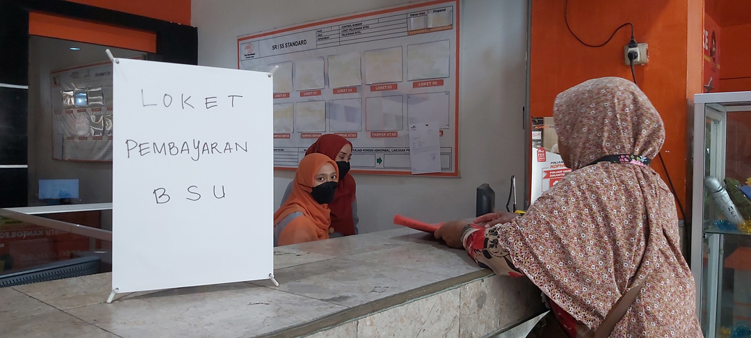 AMBIL JATAH: Seorang warga sedang memproses pengambilan BSU pada loket penyaluran BSU Kantor Pos Cabang Utama Mataram. (NURUL/LOMBOK POST)