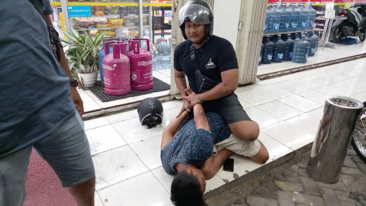 DIBORGOL: Pecatan polisi berinisial FR diborgol saat hendak transaksi sabu di depan sebuah ritel modern wilayah Rembiga, Kota Mataram, Rabu malam (9/11). (Harli/Lombok Post)