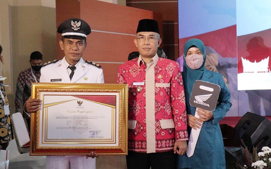 MEMBANGGAKAN: Wakil Wali Kota Mataram TGH Mujiburrahman (tengah) bersama Lurah Dayan Peken Mujtahidin dan Ketua TP PKK usai menerima penghargaan juara I Lomba Kelurahan Tingkat Nasional untuk Wilayah Regional IV, Kamis (24/11).( IST/LOMBOK POST)