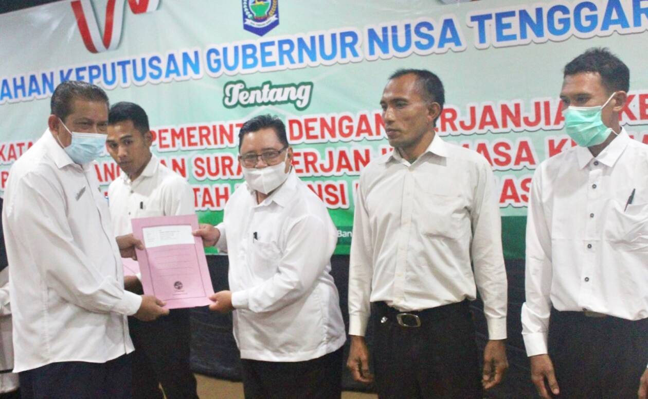 YANG DINANTI: Kepala BKD NTB Muhamad Nasir (kiri) menyerahkan SK pengangkatan PPPK kepada salah seorang guru honorer, di Graha Bakti Praja, awal Juni lalu. (Yuyun/Lombok Post)