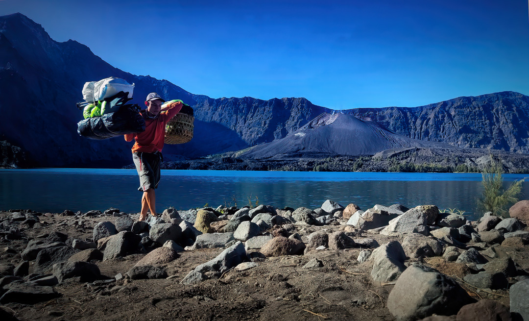 BERKAH RINJANI: Seorang porter yang membawakan barang pendaki Rinjani beberapa waktu lalu. Aktivitas pendakian terbukti mendorong perputaran uang di sana.(IVAN/LOMBOK POST)