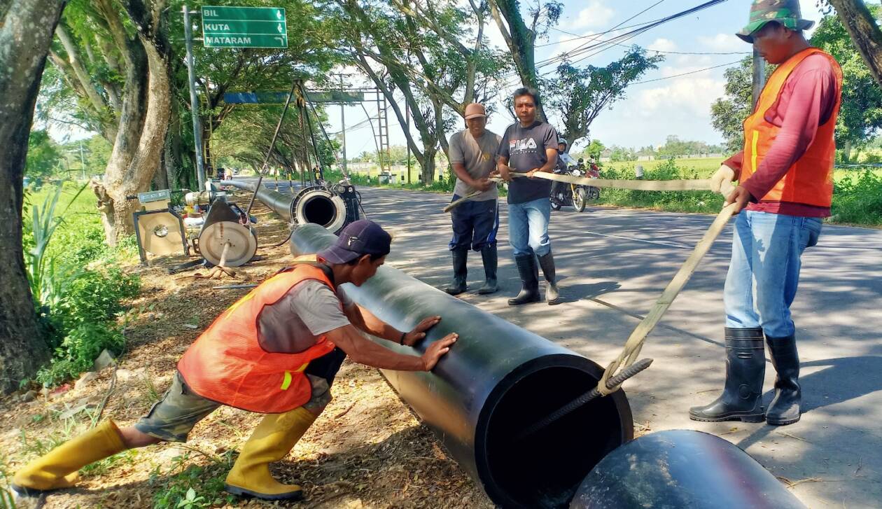 PIPANISASI: Empat pekerja saat memasang pipa untuk SPAM di Desa Penujak, Kecamatan Praya Barat, Loteng, Selasa (31/5). (Dedi/Lombok Post)