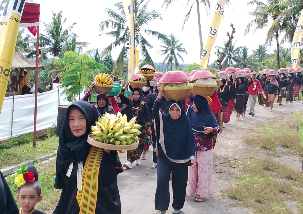 GAWE ADAT: Beberapa ibu-ibu membawa dulang dalam gawe adat Nunas Nede di Desa Kesik, Kecamatan Sikur, Minggu (18/12). (Fatih/Lombok Post)