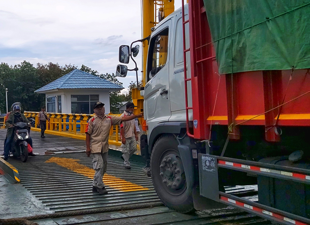ATUR KAPAL: Seorang petugas saat mengatur kendaraan yang masuk ke kapal di Pelabuhan Kayangan, Lombok Timur, beberapa waktu lalu.(NURUL/LOMBOK POST)