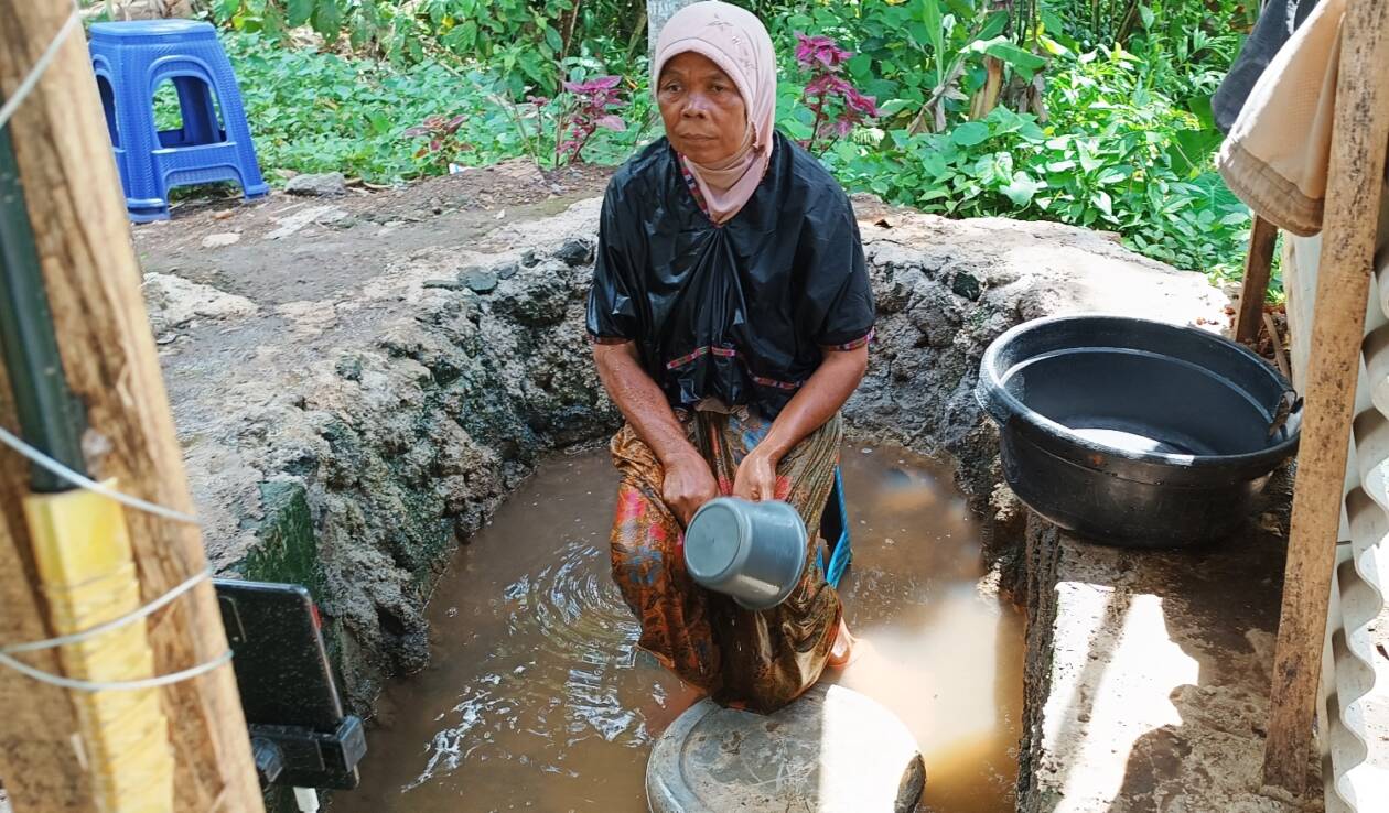 AIR KERUH: Inaq Jumawardi, salah satu pemeran TikTok nenek mandi lumpur dan mandi tengah malam di Dusun Pedek, Desa Setanggor, Kecamatan Praya Barat, Loteng saat membuat konten, Kamis (19/1). (Dedi/Lombok Post)