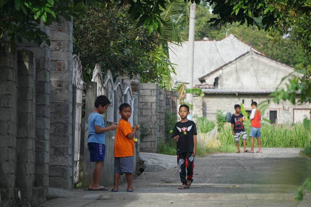 MAIN LATO-LATO: Sejumlah anak sedang berkumpul memainkan lato-lato di halaman rumah mereka di Lingkungan Rakam, Kelurahan Rakam, Kecamatan Selong, Minggu (8/1). (Fatih/Lombok Post)