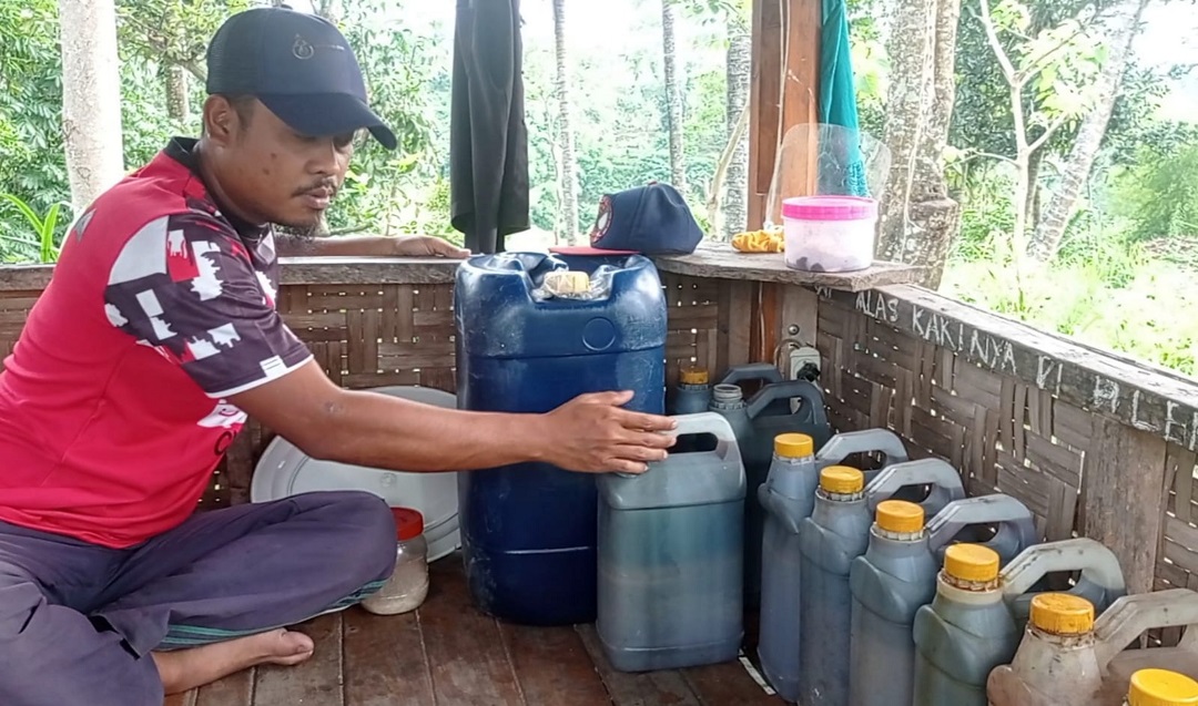 SAMPAH JADI BBM: Heri Suhirman menunjukkan BBM yang dihasilkan dari pengolahan sampah plastik, belum lama ini.(IST/LOMBOK POST)