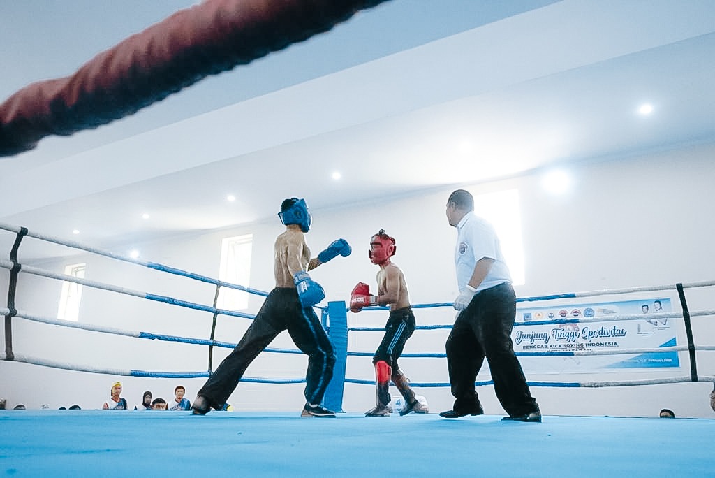 TUNTAS: Dua atlet kick boxing bertanding memperebutkan medali emas di Porprov XI/2023, kemarin (22/2).( KONI NTB FOR LOMBOK POST)