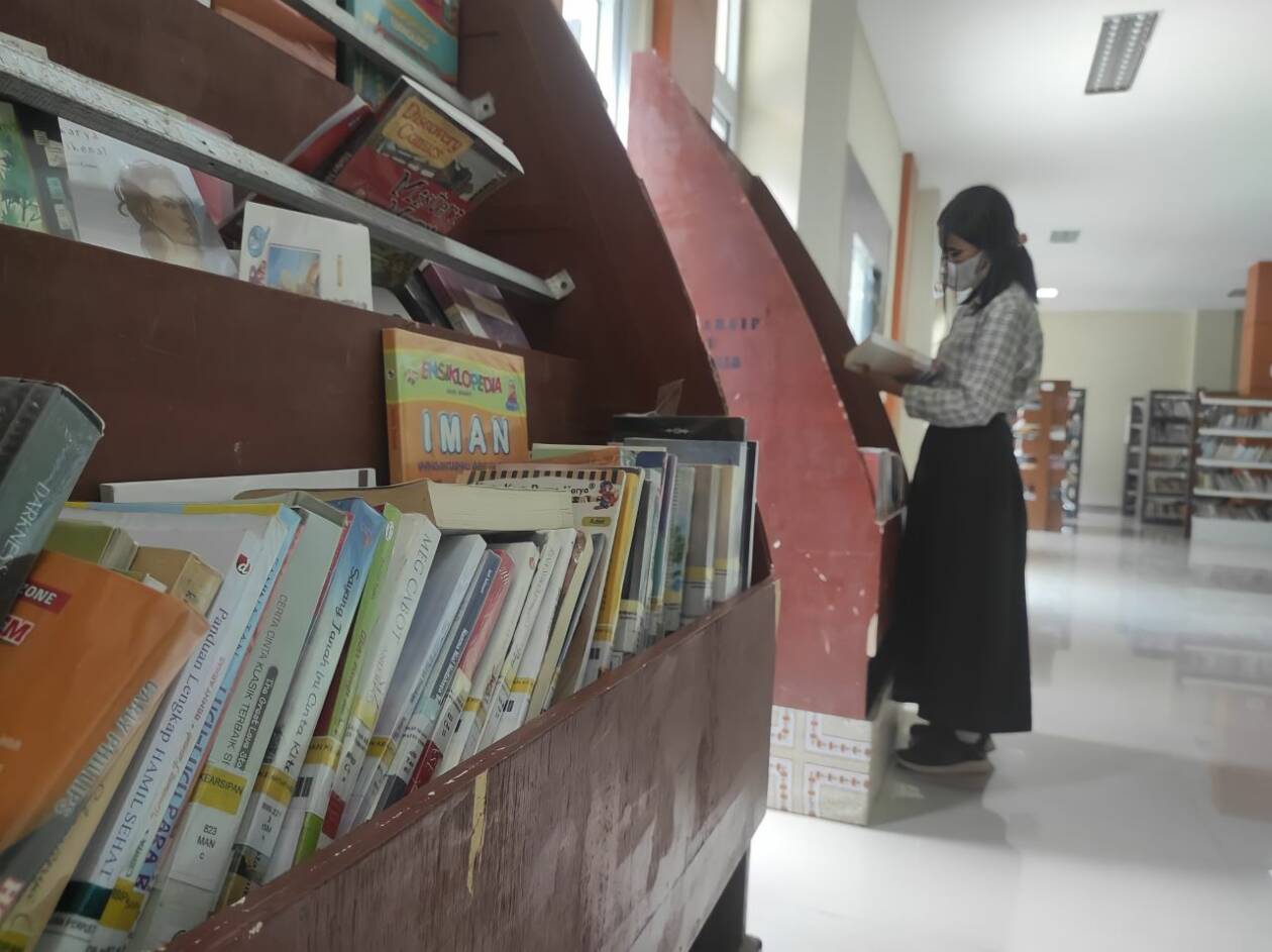 MASIH RENDAH: Salah satu pelajar KLU yang membaca buku di perpustakaan, beberapa waktu lalu. Minat baca di KLU terbilang masih rendah. (dok.Lombok Post)