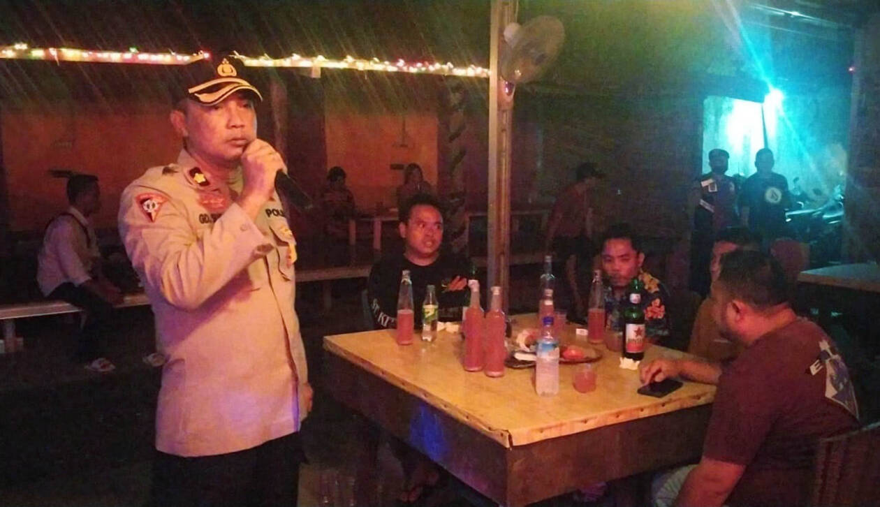 JAGA KONDUSIVITAS: Kabag Ops Polresta Mataram Kompol I Gede Sumadra Khertiawan memberikan imbauan melalui pengeras suara di salah satu kafe tuak di wilayah Kota Mataram, Sabtu malam (18/2). (Harli/Lombok Post)