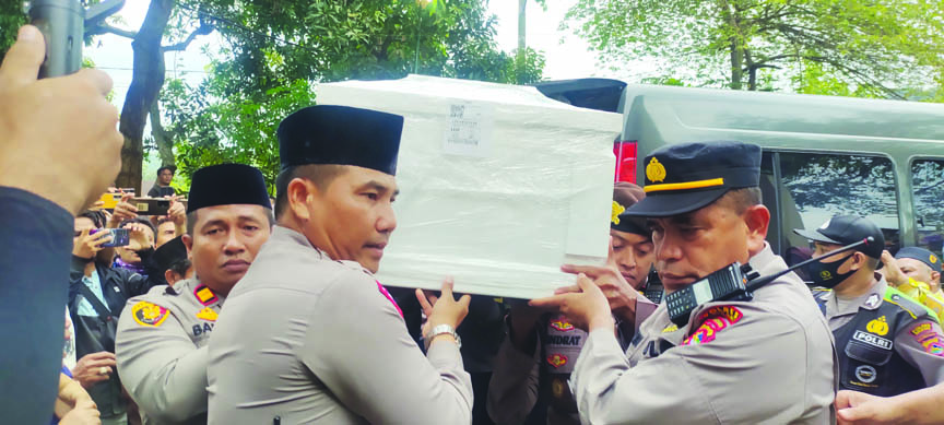 PAHLAWAN DEVISA: Personel kepolisian dari Polres Lobar mengangkat peti jenazah Irma Lestari saat baru tiba di Desa Perampuan, Kecamatan Labuapi, Kamis sore (23/2). (Habibul Adnan/Lombok Post)