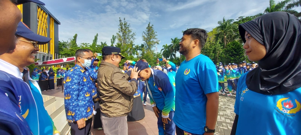 PELEPASAN KONTINGEN: Wabup Lotim H Rumaksi memasangkan topi pada kontingen Porprov NTB XI dalam acara pelepasan atlet di halaman kantor bupati Lotim, Jumat (17/2).