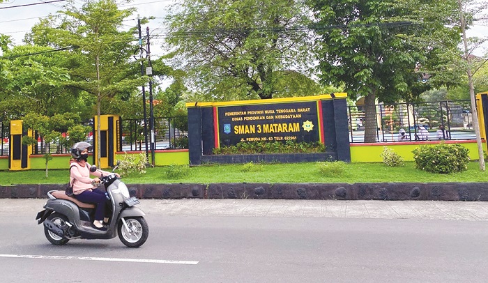 SEKOLAH DI TENGAH KOTA: Seorang pengendara sepeda motor melintas di depan SMAN 3 Mataram, Selasa (7/2).  (Yuyun/Lombok Post)
