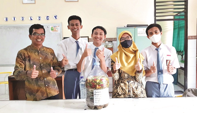 AJARKAN SETIAP PROSESNYA: Guru mata pelajaran Biologi sekaligus pembina ekskul ristek SMAN 1 Mataram Minaryo (kiri), bersama rekan guru dan siswanya memperlihatkan hasil olahan cairan eco-enzyme, beberapa waktu lalu. (SMAN 1 Mataram for Lombok Post)