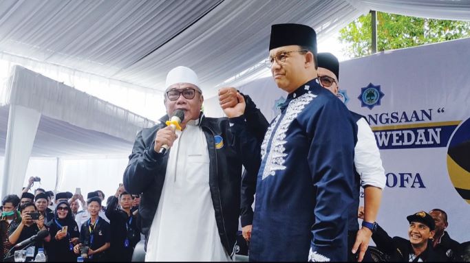 SIMBOLIK: TGH Fadli Fadil Thohir (kiri) mengenakan jaket NasDem sebagai simbol kepindahannya dari Golkar ke NasDem, kemarin (30/1). (ZAD/LOMBOK POST )