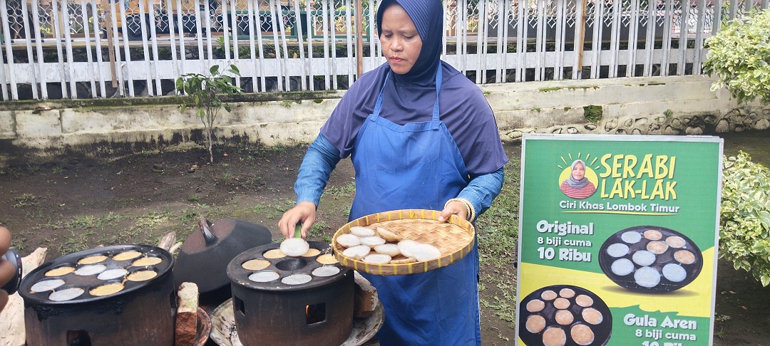 KUDAPAN TRADISIONAL: Baiq Karmah mengangkat beberapa serabi lak lak yang sudah matang dari atas tungku, belum lama ini. Lapaknya kerap menjadi langganan Dinas Pertanian dan Perkebunan NTB untuk hadir dalam berbagai kegiatan di sana. (Dewi/Lombok Post)