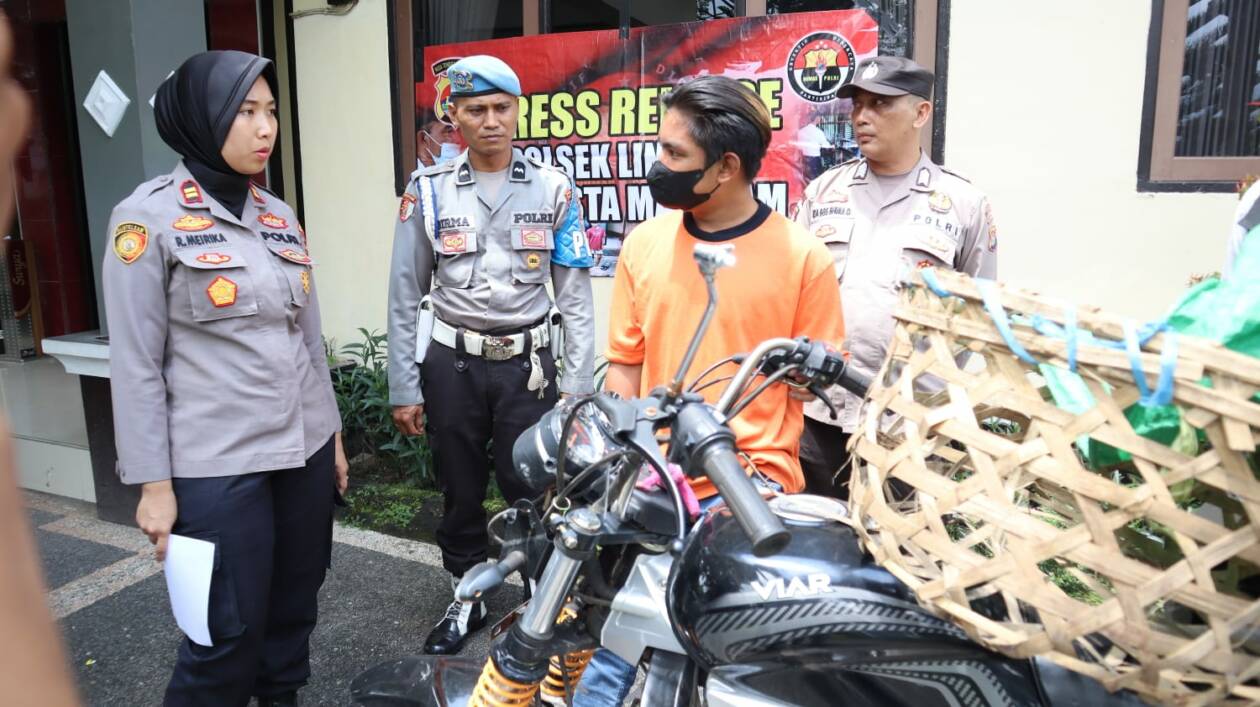 CURI IKAN: Tersangka pencuri ikan berinisial AS berdiri di samping barang bukti yang diamankan polisi di Mapolsek Lingsar, Senin (20/3). (Harli/Lombok Post)
