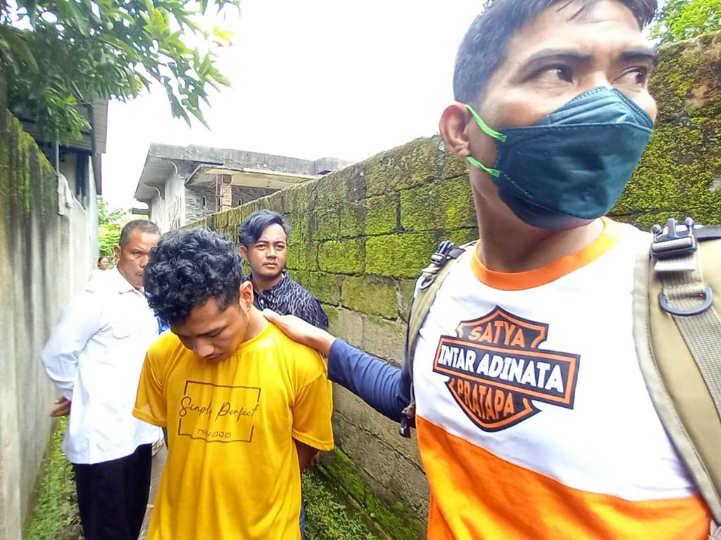 DIRINGKUS: Terduga pengedar sabu berinsial AH (menunduk) usai ditangkap di salah satu gang wilayah Sesela, Kecamatan Gunungsari, Lobar, Rabu (1/3). (Harli/Lombok Post)