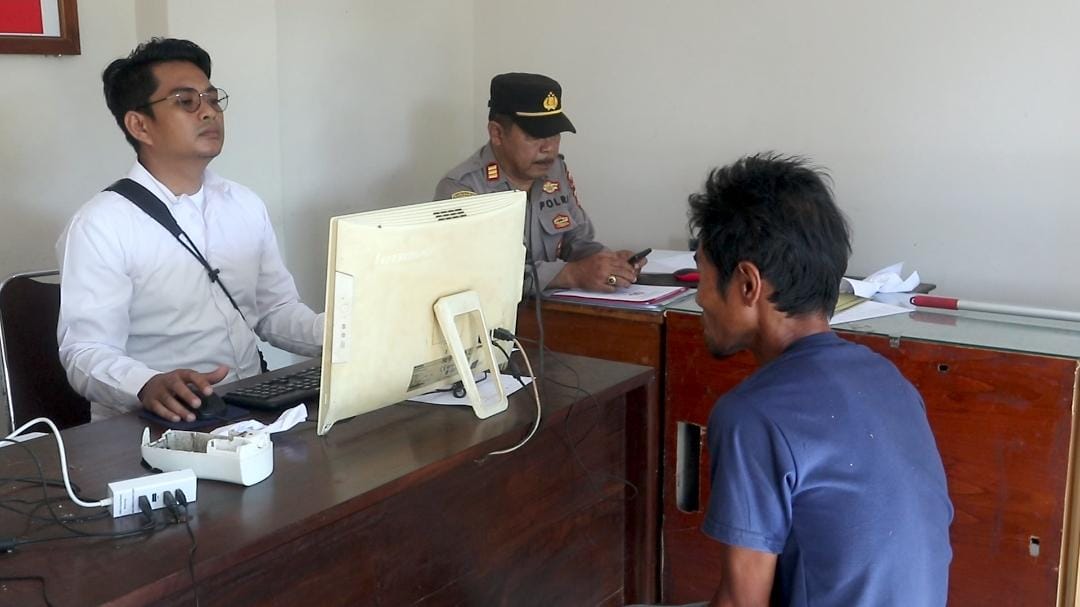 MASUK BUI: Terduga pelaku saat dimintai keterangan oleh anggota Polsek Pringgarata yang diduga menganiaya anak kandungnya, Senin (20/3). (Dewi/Lombok Post)