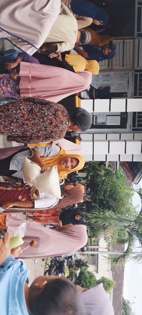 SEMRINGAH: Seorang ibu penerima manfaat terlihat bahagia mendapat beras bantuan pangan 2023 dari Bappenas yang dibagikan melalui kantor desa di Desa Labulia, Kecamatan Jonggat, Loteng, Jumat (28/4). (Dewi/Lombok Post)