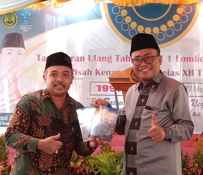 MEMBANGGAKAN: Kepala MAN 1 Lotim M Nurul Wathoni (kiri) saat memberikan buku ke-13, berjudul Gempa Lombok dan Mitos Dewi Anjani kepada Kepala Kanwil Kemenag NTB H Zamroni Aziz, di perayaan puncak HUT MAN 1 Lotim ke-32 di Selong, Rabu (17/5), (MAN 1 Lotim