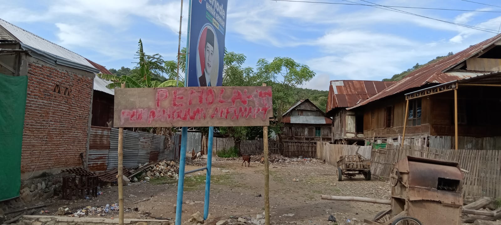 TOLAK: Warga Desa Samili, Kecamatan Woha, Bima memasang plang penolakan Alfamart di desa setempat.(Firman/Lombok Post)