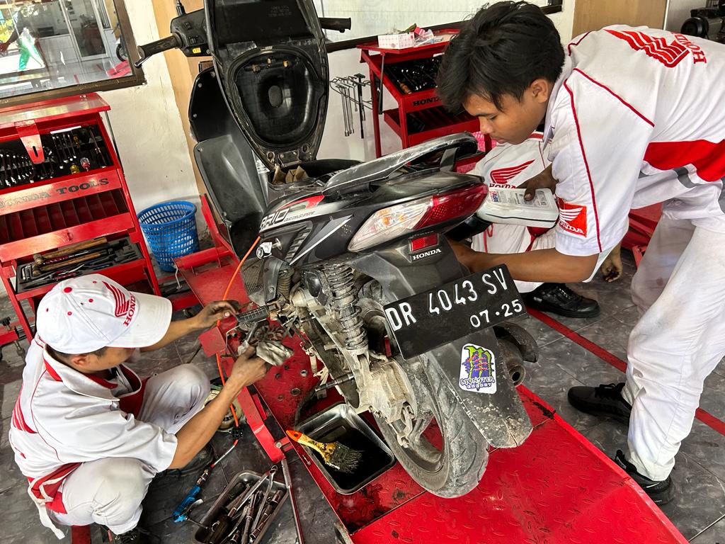 TELATEN: Dua mekanik Honda melakukan pemeriksaan terhadap sepeda motor salah satu konsumen. (HONDA FOR LOMBOK POST)
